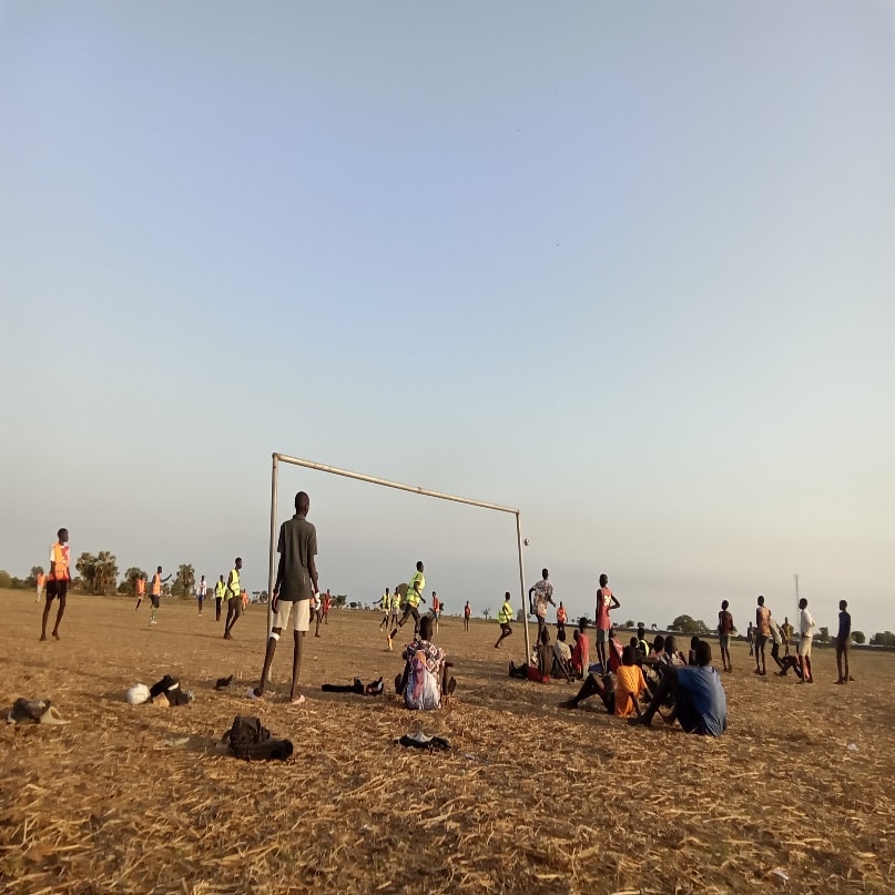 Children draw and paste pictures in groups, explaining meanings that included a school, church, and the South Sudan flag
